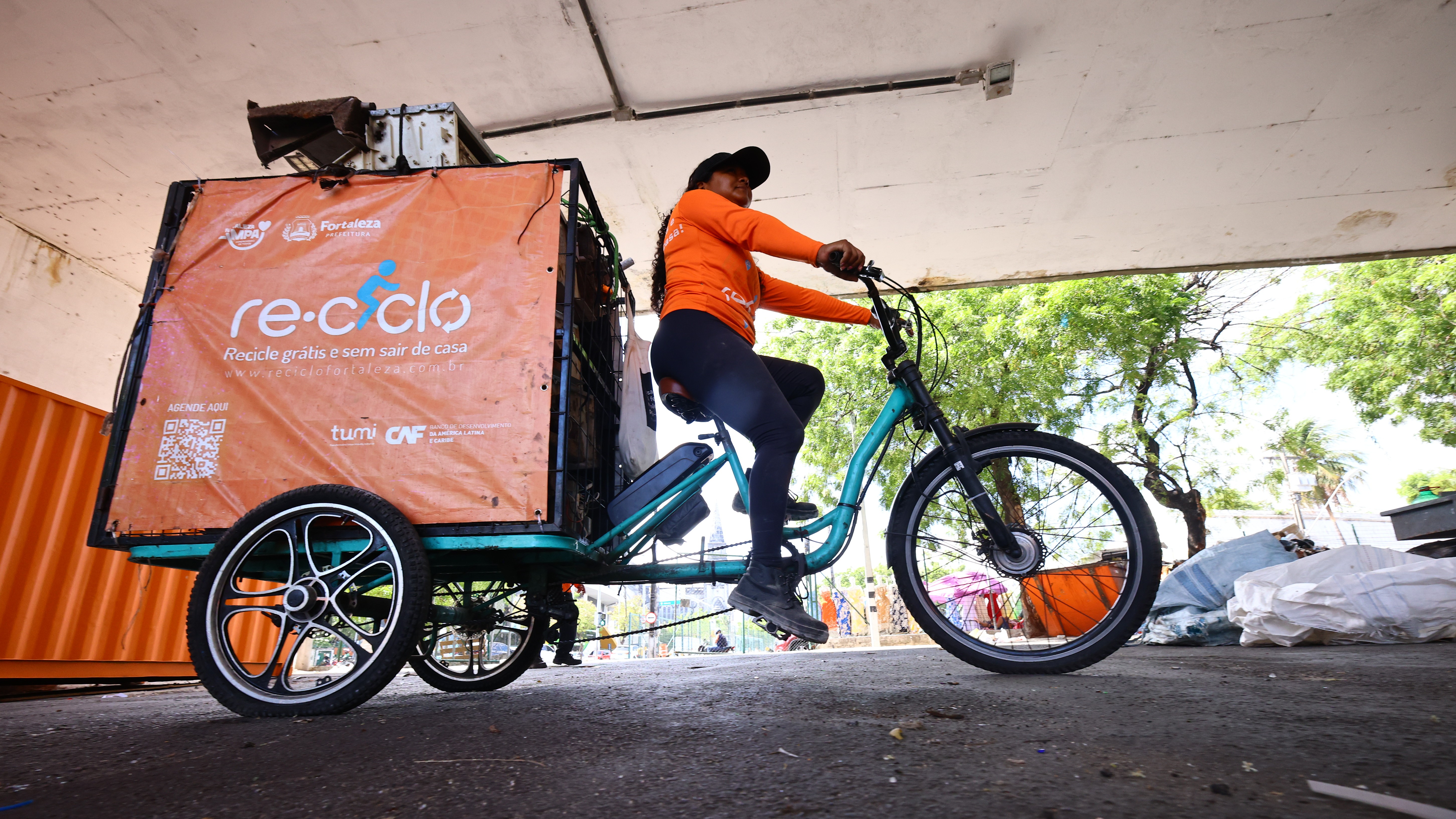 mulher andando no triciclo elétrico do Reciclo